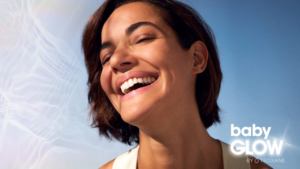 Model smiling advertising Baby Glow by Teoxane