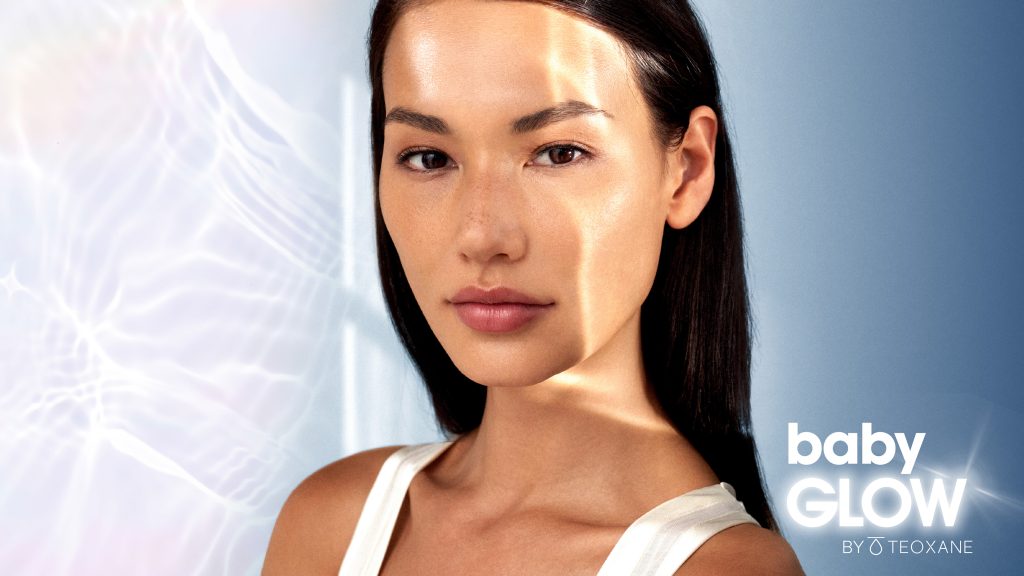 Model with long dark hair looking at the camera advertising Baby Glow by Teoxane